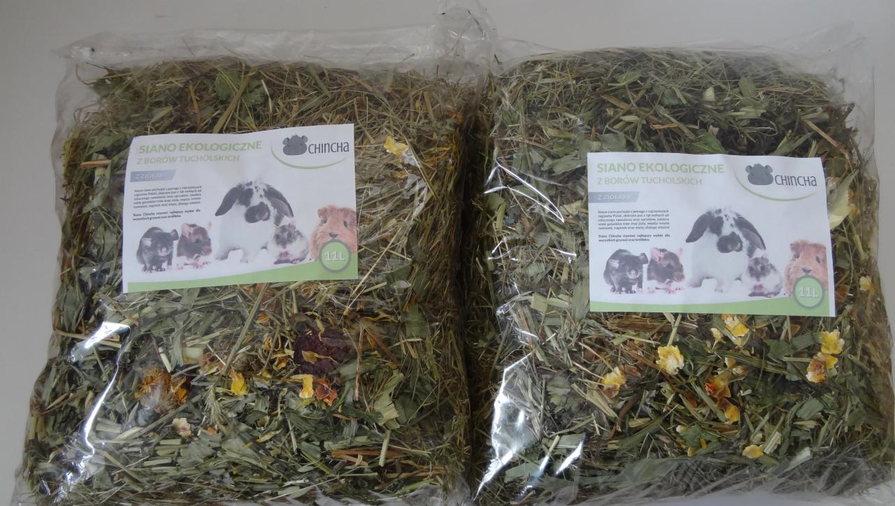 Dwa foliowe worki z ekologicznym sianem z ziołami dla gryzoni, z etykietą producenta Chincza z wizerunkiem królików i świnek morskich.