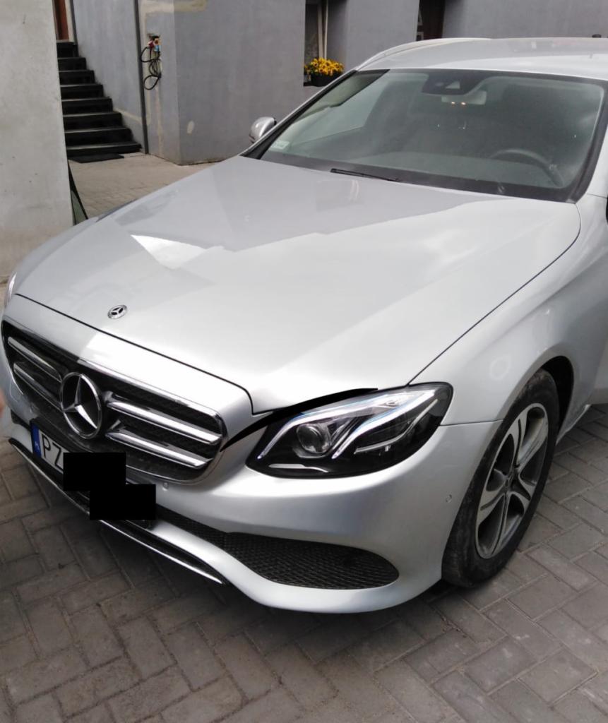 Srebrny Mercedes klasy E po naprawie blacharsko-lakierniczej, widoczne odbicie w lakierze i czyste felgi.