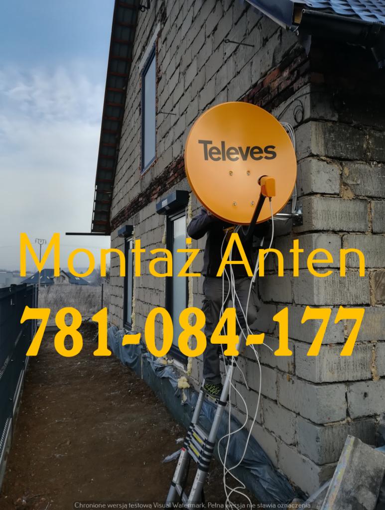 Pracownik na drabinie montuje antenę satelitarną Televes na ścianie budynku z szarego pustaka. Widoczne przewody antenowe i fragment dachu. Ściana ocieplana styropianem.