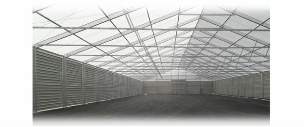 Wnętrze pustej hali z konstrukcją stalową, ściany z blachy trapezowej, widoczna metalowa konstrukcja dachu.