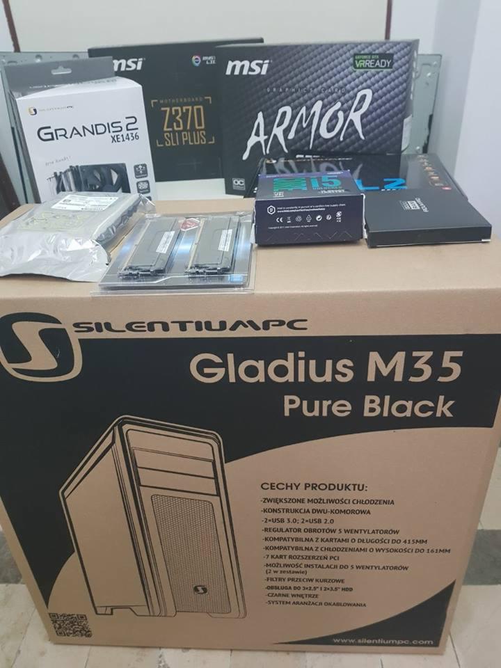 Komponenty komputerowe: pudełko obudowy SilentiumPC Gladius M35, płyta główna MSI Z370 SLI PLUS, karta graficzna MSI Armor, chłodzenie Grandis 2 XE1436, pamięć RAM w opakowaniu i inne akcesoria...