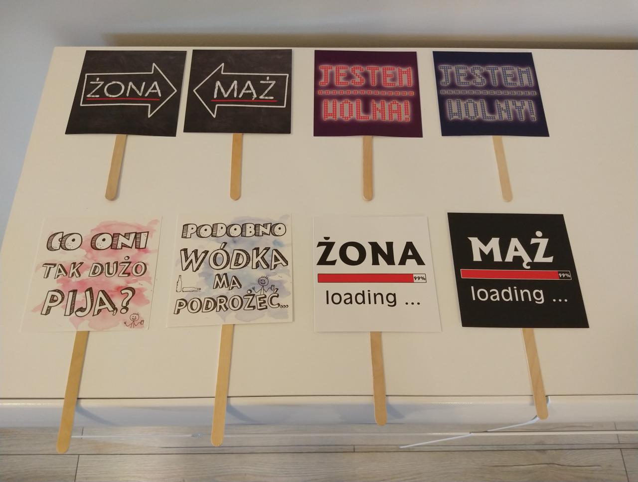 Różnorodne, humorystyczne tabliczki na patykach z napisami 'Żona', 'Mąż', 'Jestem wolna!', 'Jestem wolny!', 'Co oni tak dużo piją?', 'Podobno wódka ma podróże', 'Żona loading...', 'Mąż loading...',...