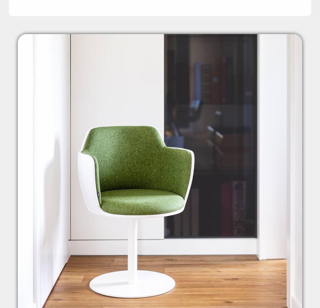 Nowoczesne krzesło obrotowe z zielonym siedziskiem i białym stelażem na drewnianej podłodze, widok z Bydgoszczy.