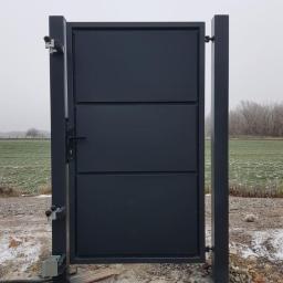 Marcin Czemerajda Ogrodzenia i Konstrukcje Stalowe - Nowoczesna, grafitowa brama wjazdowa z trzema poziomymi panelami, zamontowana na betonowych słupkach z automatyką, na tle zaśnieżonego pola i drzew.