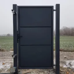 Nowoczesna, grafitowa brama wjazdowa z trzema poziomymi panelami, zamontowana na betonowych słupkach z automatyką, na tle zaśnieżonego pola i drzew.