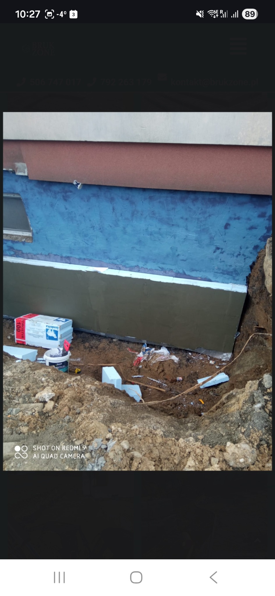 Ocieplenie fundamentów budynku w trakcie prac. Widoczny wykop, izolacja termiczna i materiały budowlane. Fundament zabezpieczony przed wilgocią.