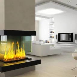 Nowoczesny kominek narożny z trzema szklanymi ścianami, płomienie widoczne z trzech stron, w minimalistycznym salonie z białymi meblami i oświetleniem punktowym.