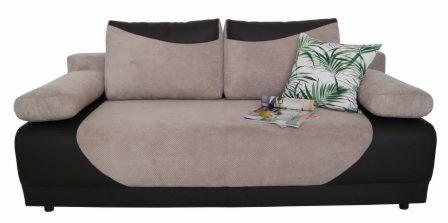 Rozkładana sofa w odcieniach beżu i brązu z poduszką w tropikalne liście i zwiniętą gazetą na siedzisku.