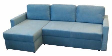 Rozkładana sofa narożna z błękitną tapicerką, widoczna na białym tle, z poduszkami o prostych kształtach.