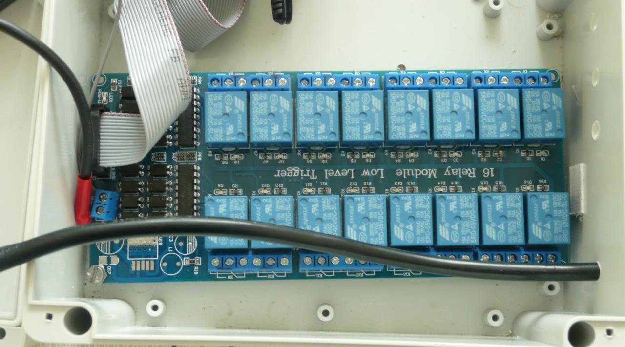 Wnętrze skrzynki z modułem 16 przekaźników niskiego poziomu sterowania, widoczne przewody i złącza, układ scalony.