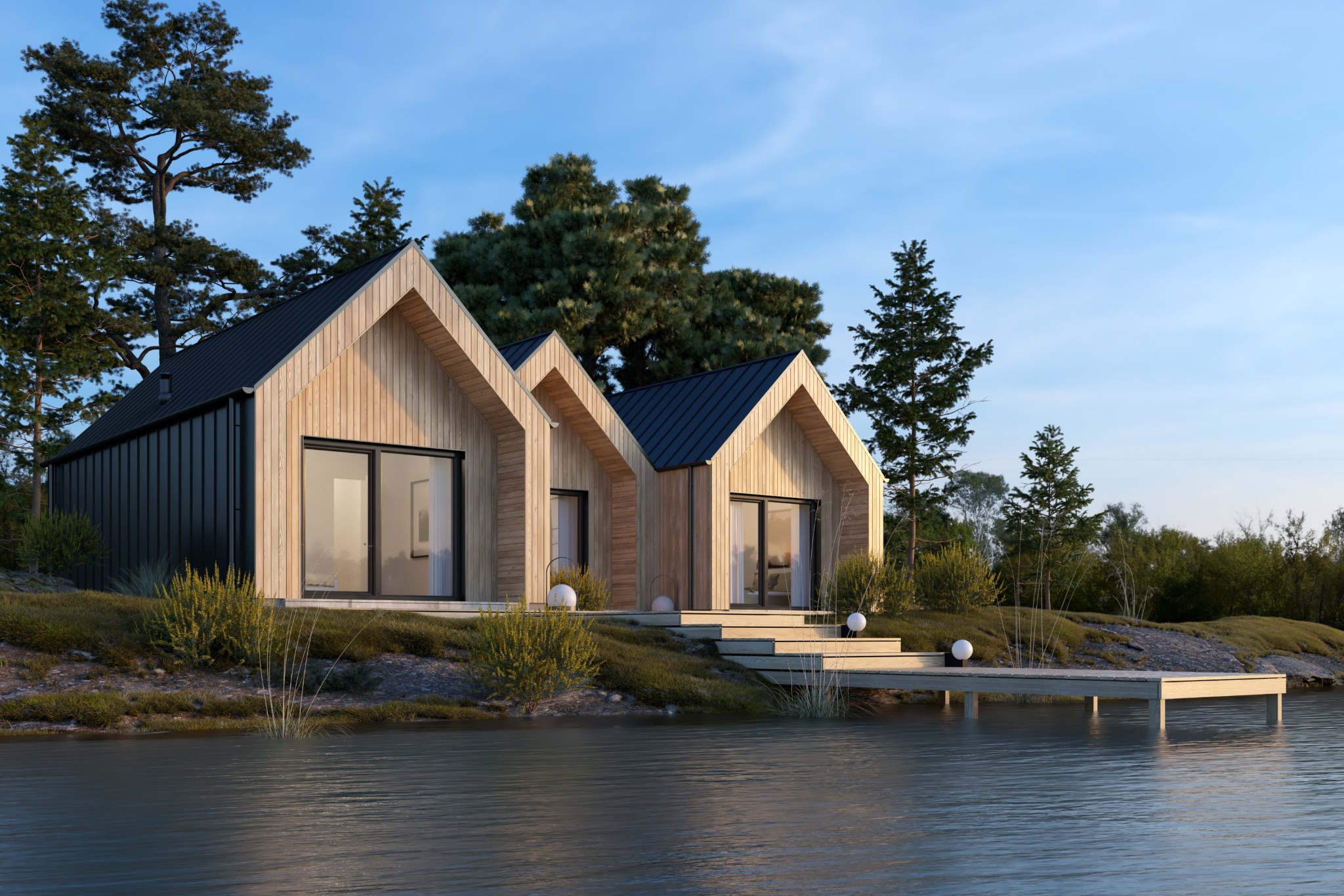 Dwa nowoczesne domy z drewna i czarnej blachy, połączone schodami prowadzącymi do drewnianego pomostu nad wodą, otoczone zielenią i drzewami.