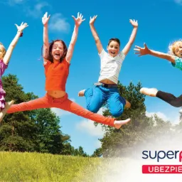Cztery roześmiane dzieci skaczą w powietrzu na tle zielonego pola i błękitnego nieba, logo firmy ubezpieczeniowej w prawym dolnym rogu.