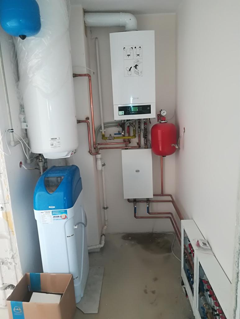 Nowa instalacja grzewcza z piecem gazowym, zasobnikiem ciepłej wody i zmiękczaczem wody w kotłowni w Orońsku, widoczne miedziane rury i rozdzielacz.