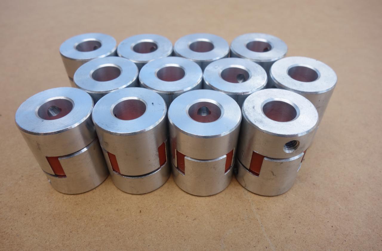 Zestaw dziesięciu metalowych sprzęgieł elastycznych z wkładką z tworzywa, widoczne gwintowane otwory mocujące.