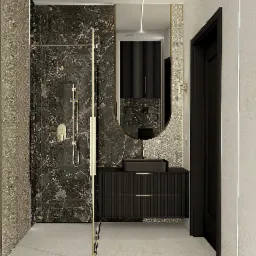 Elegancka łazienka: kabina prysznicowa ze złotymi detalami, czarna umywalka na szafce z ryflowanym frontem, owalne lustro i marmurowe wykończenie ścian.