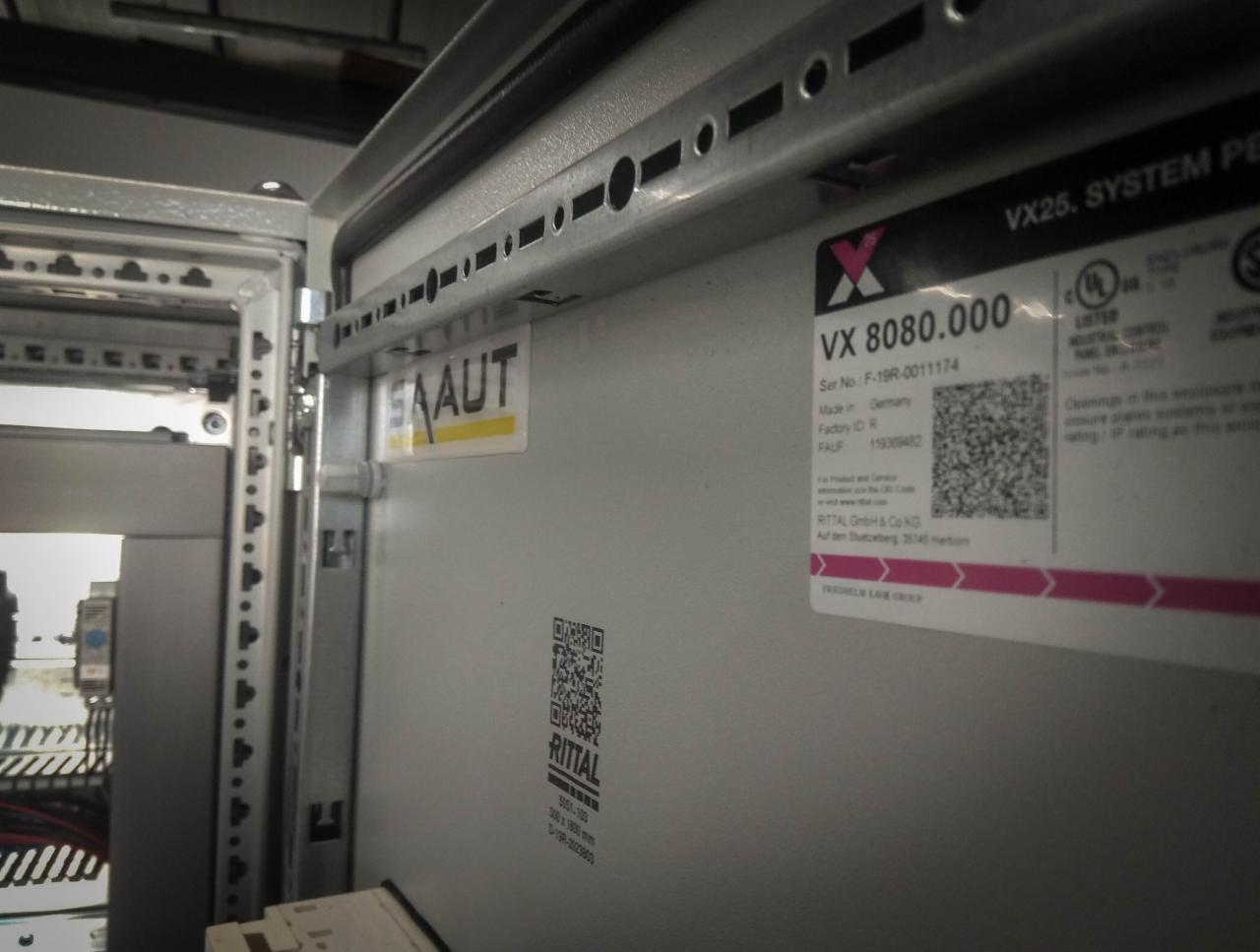 Wnętrze szafy sterowniczej Rittal VX25 z widoczną tabliczką znamionową VX 8080.000, naklejką SAAUT, kodem QR i elementami montażowymi.