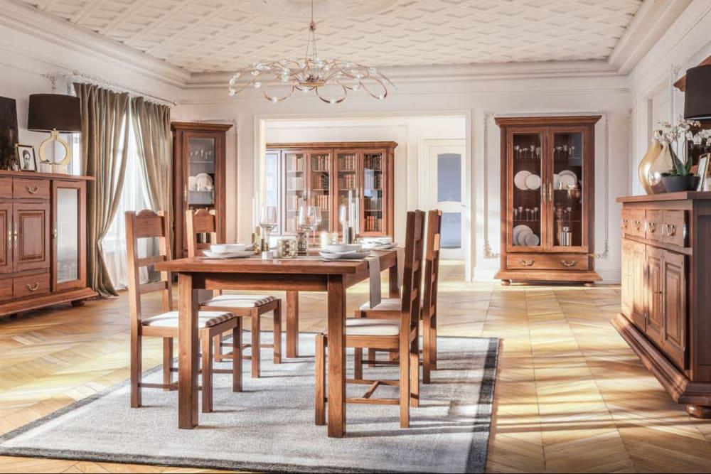 Jadalnia w klasycznym stylu: drewniany stół z zastawą, krzesła z jasnymi siedziskami, witryny z ekspozycją naczyń, parkiet w jodełkę i ozdobny żyrandol.