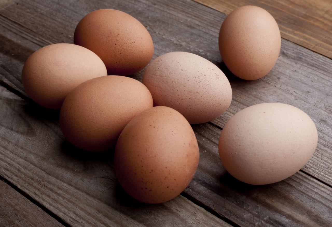 Siedem brązowych i beżowych produktów na drewnianym stole z widoczną strukturą drewna.