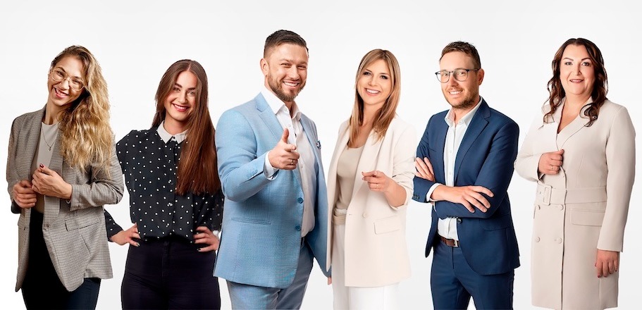 Zespół sześciu uśmiechniętych osób w eleganckich strojach na białym tle. Kobiety w żakietach, mężczyźni w garniturach. Zgrany team.