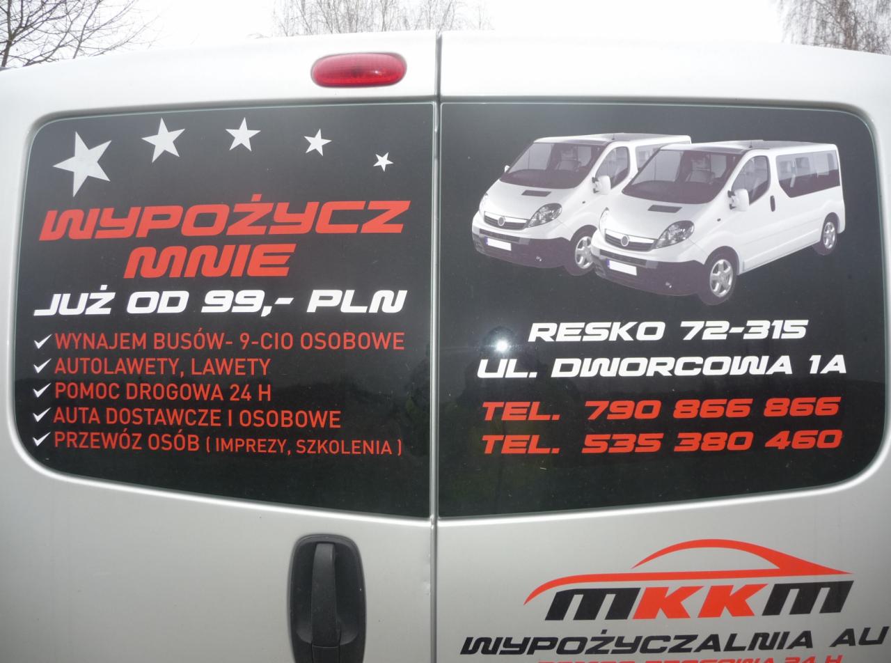 Tył srebrnego busa z naklejkami reklamowymi firmy MKKM oferującej wynajem busów 9-osobowych, autolawet, pomoc drogową 24h oraz przewóz osób na imprezy i szkolenia w Resku.