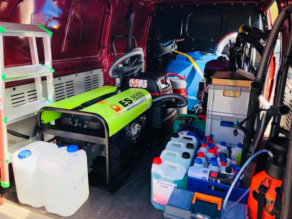 Wnętrze furgonetki z profesjonalnym sprzętem czyszczącym: generator ES 8000, drabina, pojemniki z płynami, odkurzacz przemysłowy i akcesoria w burgundowym wnętrzu.
