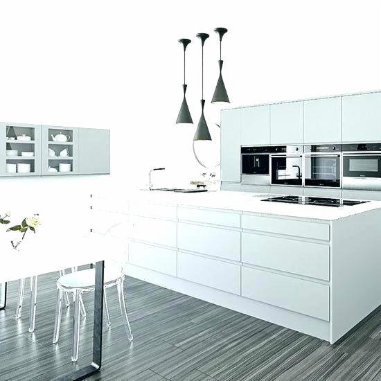 Minimalistyczna, biała kuchnia z wyspą i trzema wiszącymi lampami w kształcie stożków, widoczne przeszklone szafki wiszące, stół z przezroczystymi krzesłami i podłoga imitująca drewno.