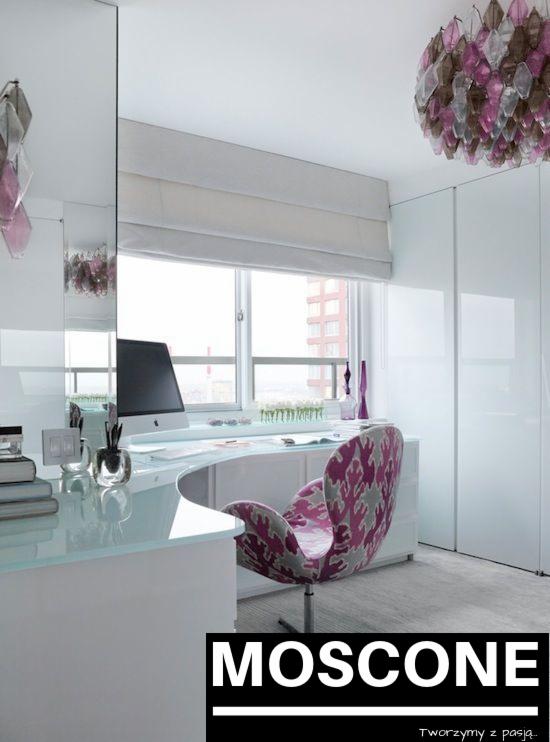 Białe rolety rzymskie zamontowane w nowoczesnym gabinecie z białymi meblami i designerskim fotelem, widok na miasto przez okno.