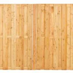 Panelowy płot z pionowo ułożonych, jasnych desek, z widocznymi detalami łączeń i naturalnym usłojeniem drewna.