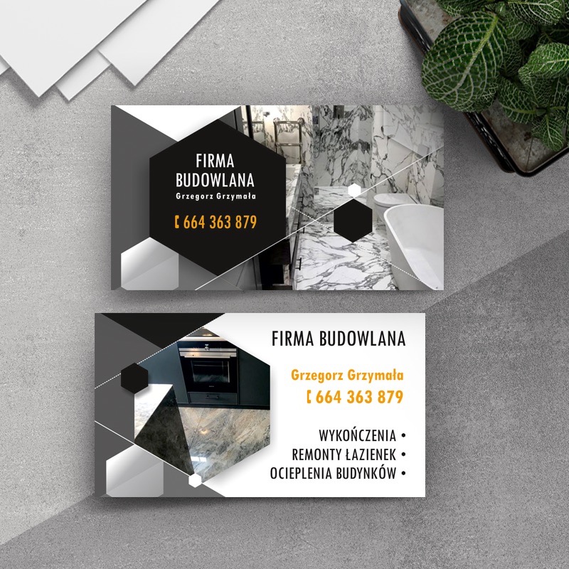 Wizytówka firmy budowlanej Grzegorza Grzymały z numerem telefonu, prezentująca zdjęcia łazienki z marmurowymi płytkami i kuchni z czarnymi szafkami, otoczona luźnymi kartkami i rośliną w doniczce.