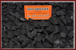 Kupa czarnego węgla kamiennego z pomarańczową tabliczką reklamową z napisem 'EKO-Groszek' oraz numerem telefonu i adresem strony internetowej.