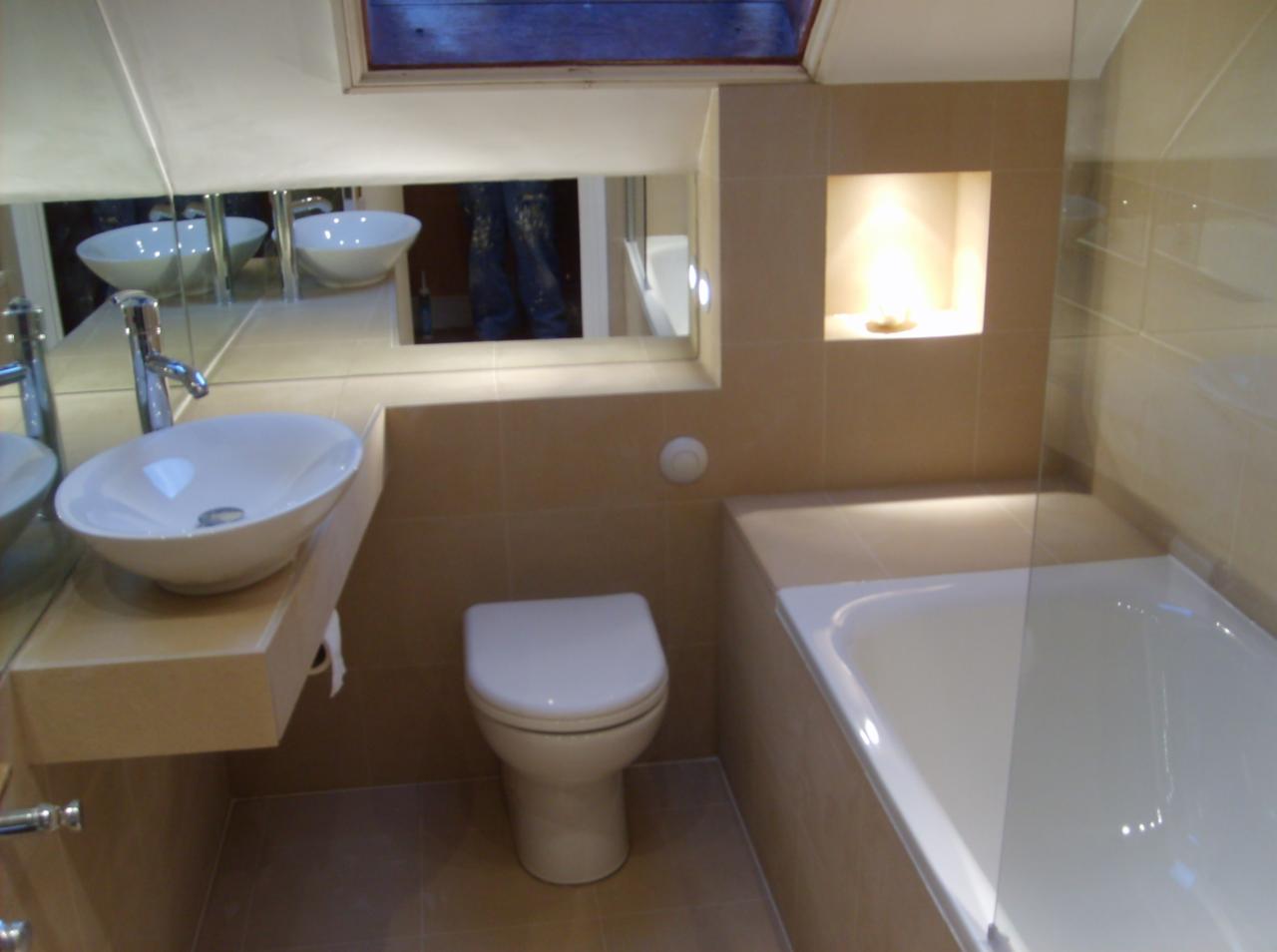 Jasna łazienka w Świeciu z umywalką nablatową, toaletą i wanną, wykończona beżowymi płytkami. W lustrze odbija się osoba w dżinsach.