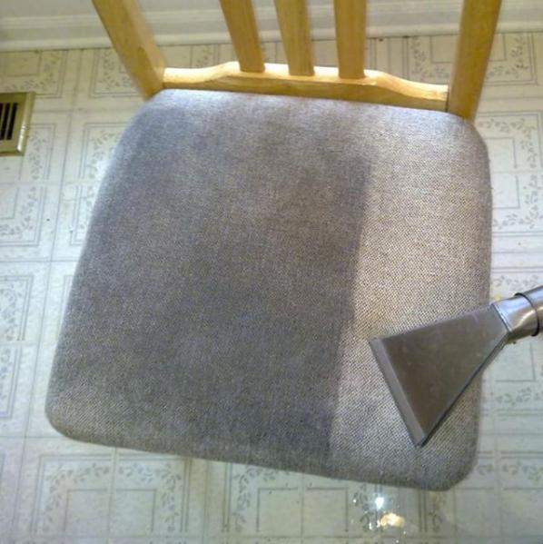 Fragment krzesła z szarą tapicerką w trakcie czyszczenia parowego, widoczna różnica w kolorze pomiędzy wyczyszczoną a nie wyczyszczoną częścią siedziska, na podłodze widoczne ślady wody.