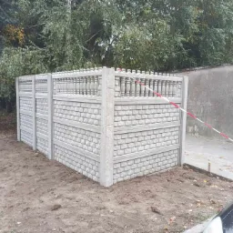 Nowo postawiony, prefabrykowany, betonowy płot segmentowy z dekoracyjną górą, otoczony taśmą ostrzegawczą na placu budowy.