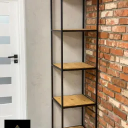 Metalowy regał z drewnianymi półkami, czarna rama, tło z cegły, widoczne logo firmy spawalniczej w lewym dolnym rogu.