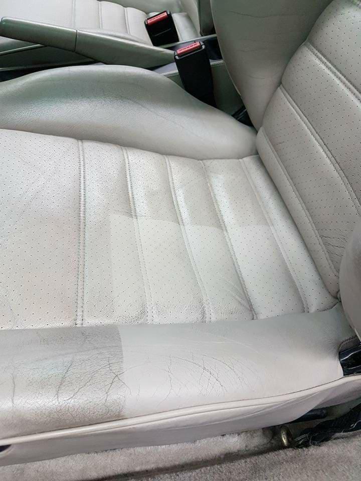 Jasnoszare skórzane siedzenie samochodowe, połowa wyczyszczona, ukazująca różnicę przed i po zabiegu, widoczne perforacje i szwy.