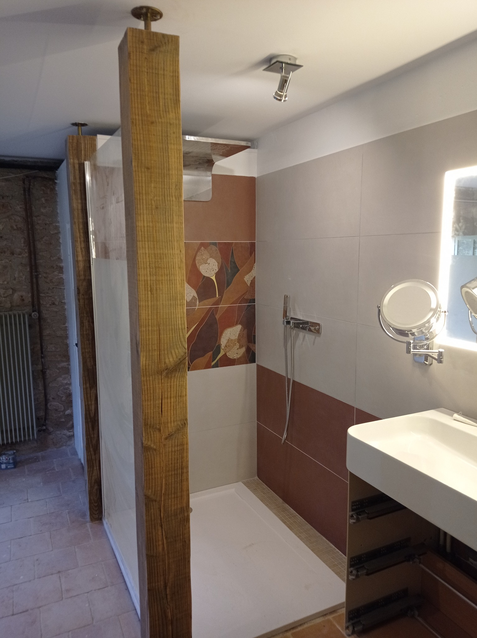 Stylowa kabina prysznicowa z drewnianymi belkami w wykończonej łazience. Nowoczesny design z płytkami i umywalką w Kielcach. Detal wykończenia.