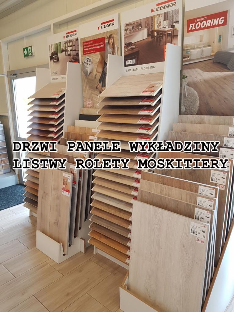 Ekspozycja paneli podłogowych marki Egger w sklepie, różne odcienie drewna, widoczne ceny na próbkach.