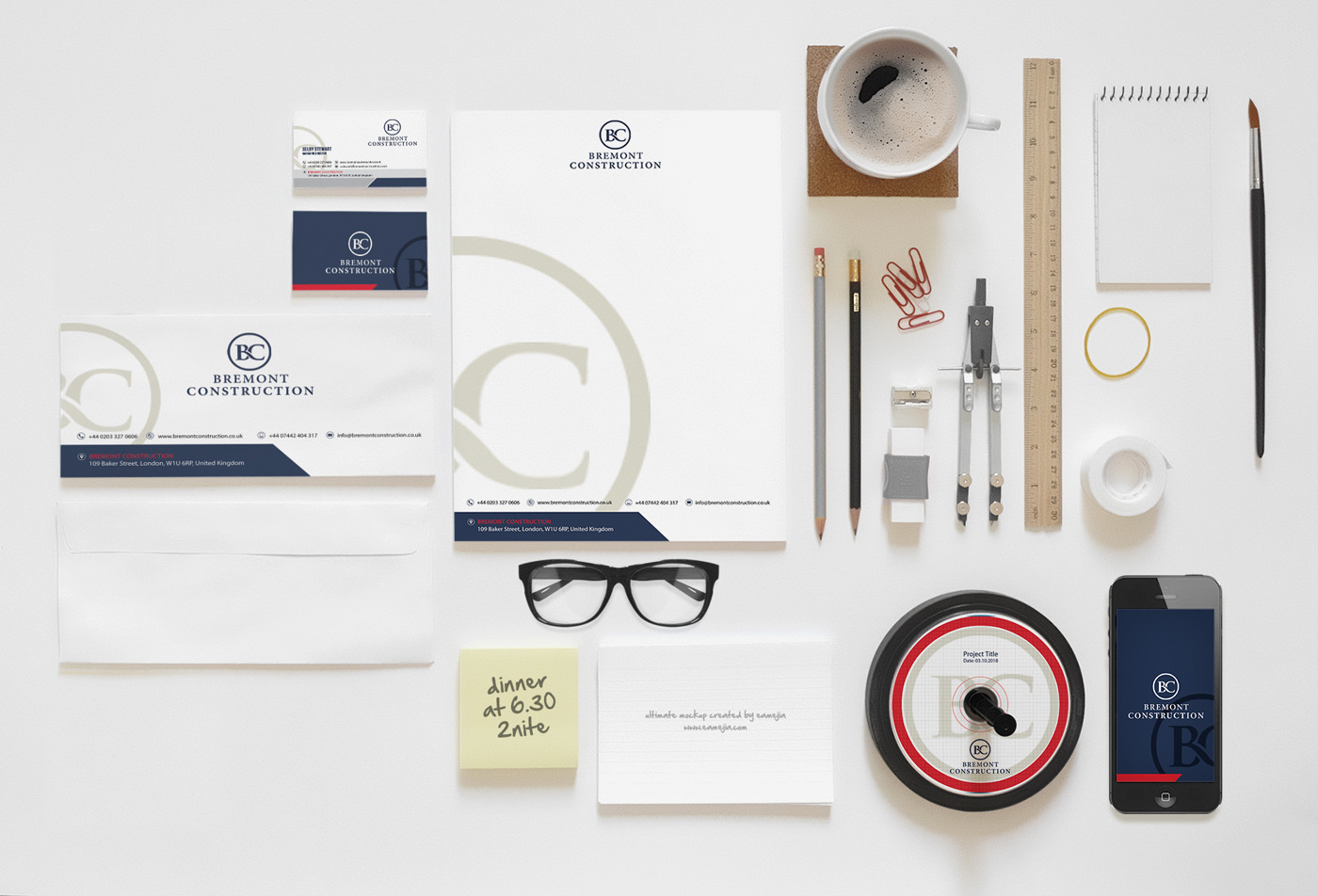 Identyfikacja wizualna firmy Bremont Construction: wizytówki, papier firmowy, koperta, notatnik, telefon z logo, przybory kreślarskie, kawa, notatka samoprzylepna i płyta CD z projektem, ułożone...
