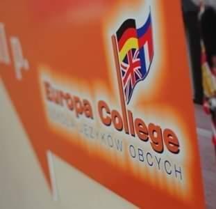 Pomarańczowy szyld z logotypem 'Europa College' i flagami Wielkiej Brytanii, Niemiec i Hiszpanii, symbolizujący naukę języków obcych.
