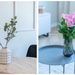 Etalon Estate Group - Jasne wnętrze z okrągłym drewnianym stolikiem i białym wazonem z zielonymi gałązkami po lewej oraz szarym stolikiem i ciemnym wazonem z różowymi różami po prawej stronie.