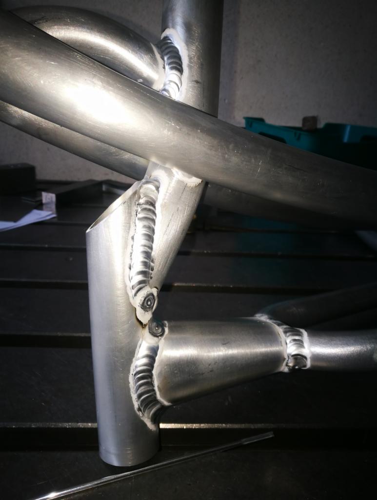 Metalowa konstrukcja z rur połączonych precyzyjnymi spawami, widoczne ślady obróbki i charakterystyczne spoiny.