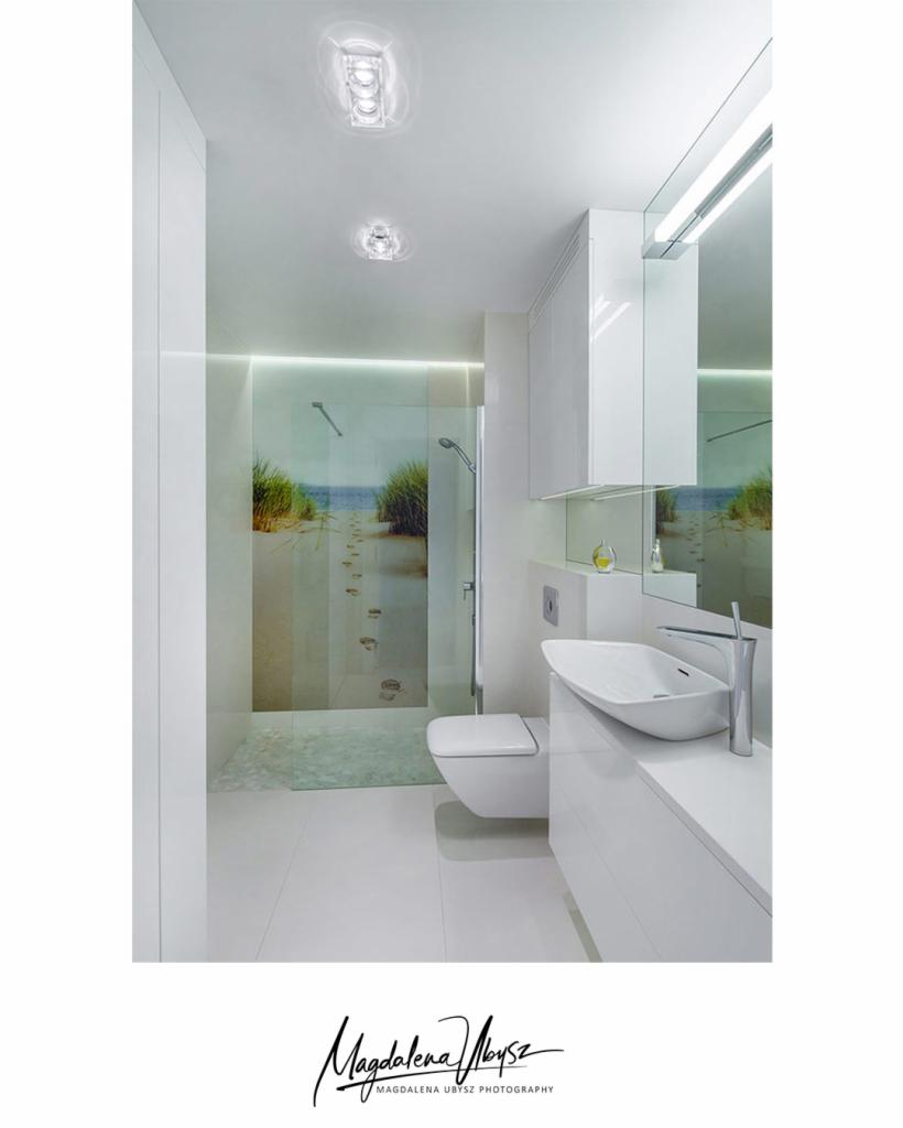 Minimalistyczna, całkowicie biała łazienka w Gdańsku z kabiną prysznicową z motywem plaży i śladami stóp, wiszącą toaletą i nowoczesną umywalką nablatową.