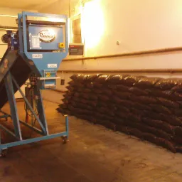 Urządzenie do pakowania w worki w Zaborowicach, z rzędem worków wypełnionych węglem w tle.