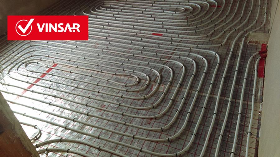 Instalacja ogrzewania podłogowego z rur ułożonych na siatce, widoczne logo firmy VINSAR w lewym górnym rogu.