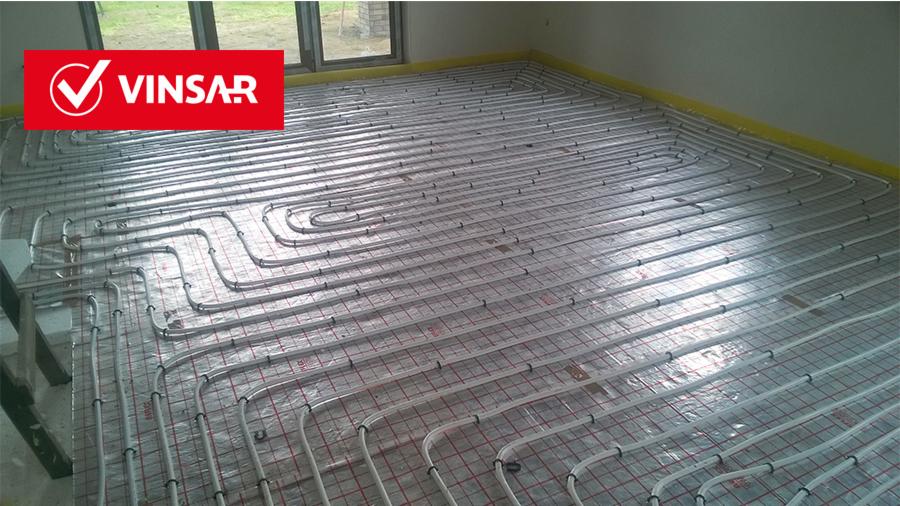 Montaż ogrzewania podłogowego z rur w nowym budownictwie we Wrocławiu, widoczna siatka montażowa i logo producenta VINSAR w lewym górnym rogu.