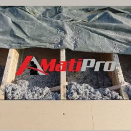 Poddasze w trakcie izolacji wełną mineralną, widoczne krokwie, folia ochronna i logo firmy nałożone na zdjęcie.