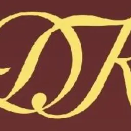 Stylizowane, złote litery DK na bordowym tle. Logo firmy.