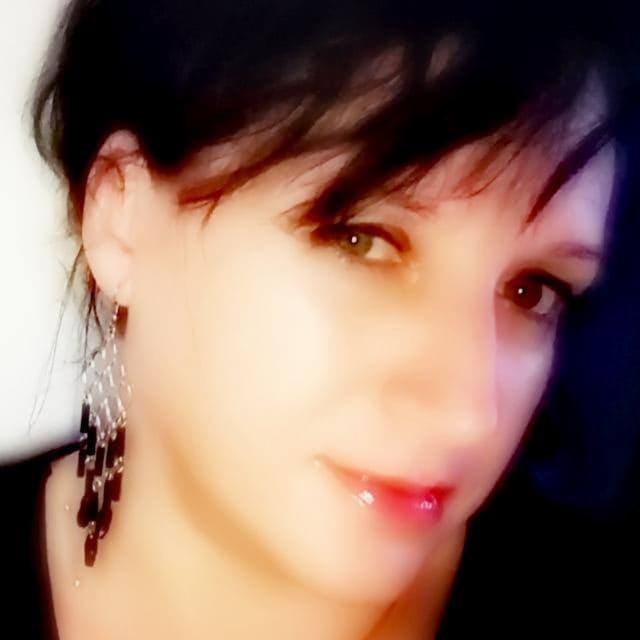 Portret kobiety z kolczykami, ciemne włosy, makijaż, uśmiech