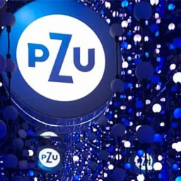 Iluminacja z logo PZU w przestrzeni z licznymi, małymi, kulistymi lampkami w odcieniach błękitu i bieli, tworzącymi efekt głębi.