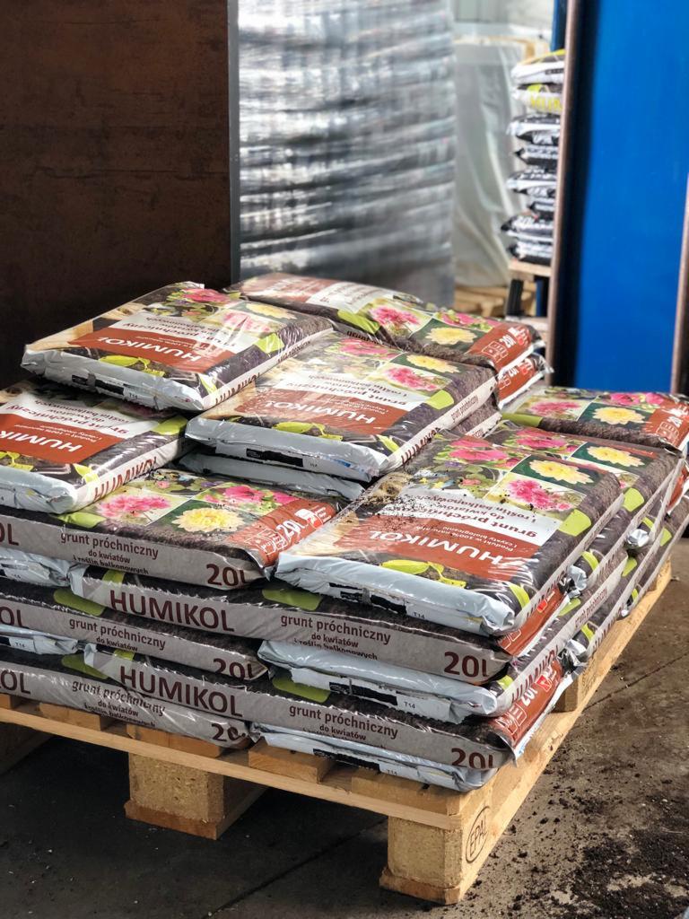 Paleta z workami ziemi próchniczej do kwiatów marki Humikol, ułożonymi warstwami w magazynie.